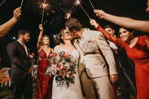 Bride and groom kissing surrounded by guests with sparklers