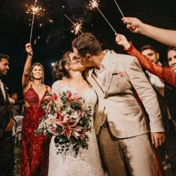 Bride and groom kissing surrounded by guests with sparklers