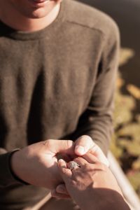 A man holding a women’s hand with a ring after proposing