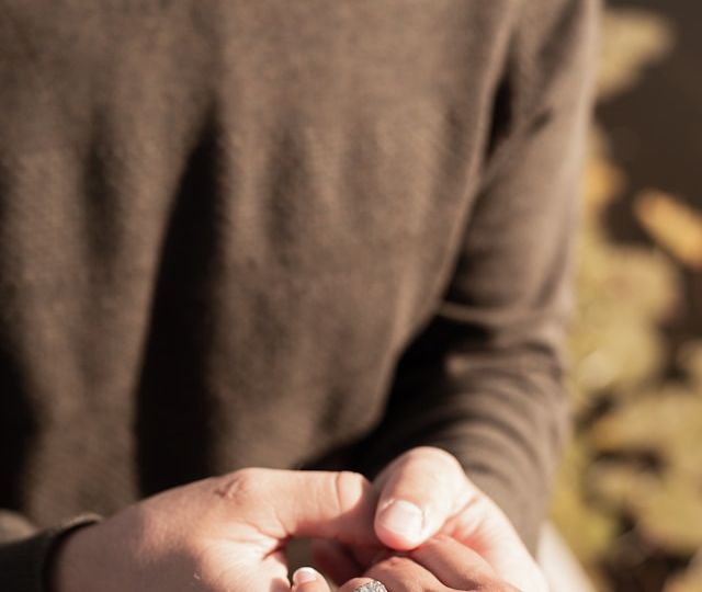 A man holding a women’s hand with a ring after proposing